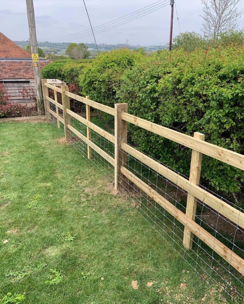 This is a photo of post and rail fencing in a garden. Installed by Fast Fix Fencing