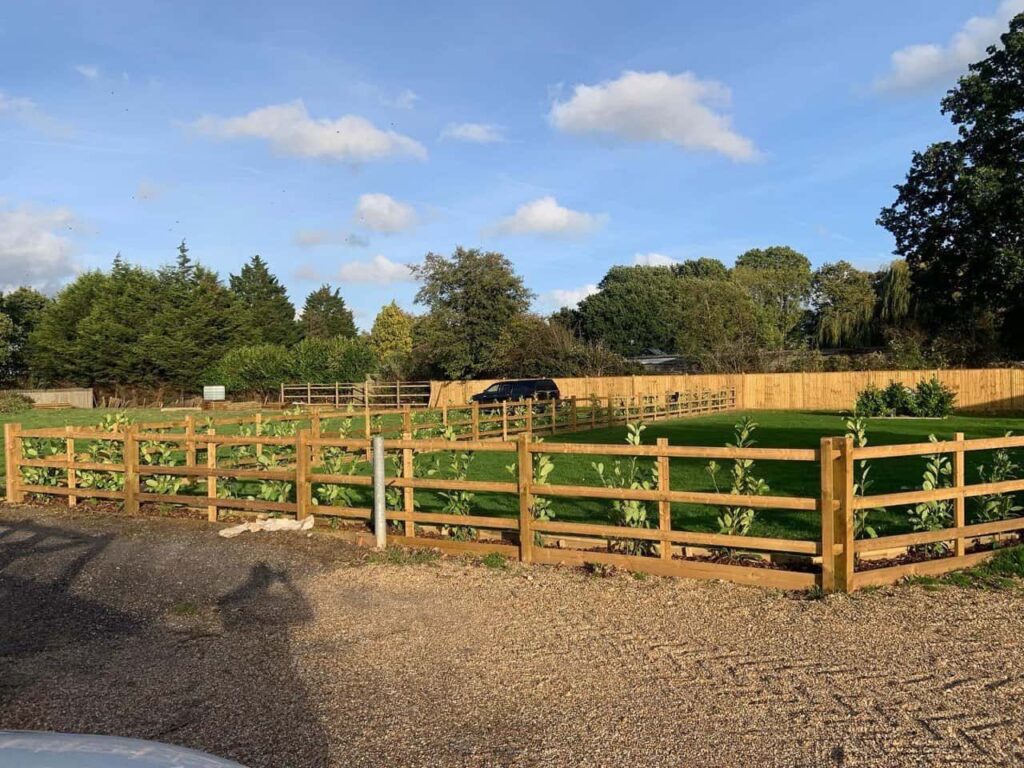 This is a photo of post and rail fencing with a gravel board installed at the base to create a flower bed, and at the rear is feather edge fencing along the edge of the garden. All works carried out by Fast Fix Fencing