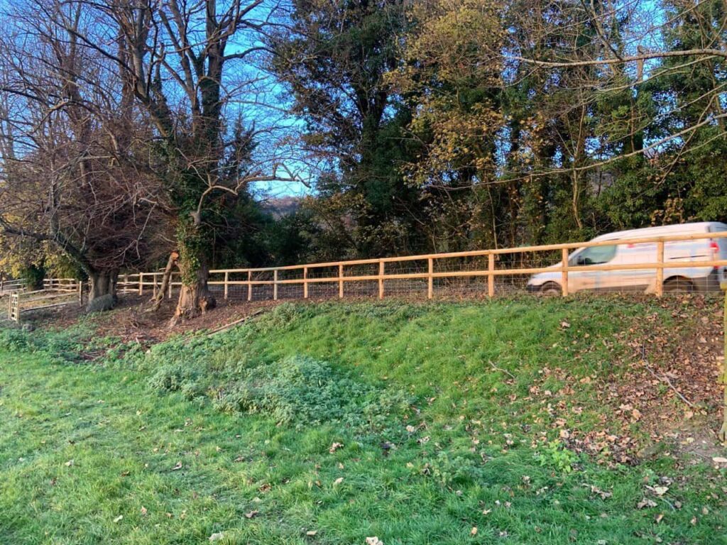 This is a photo of stock fencing installed around the edge of a field next to a road. Installed by Fast Fix Fencing